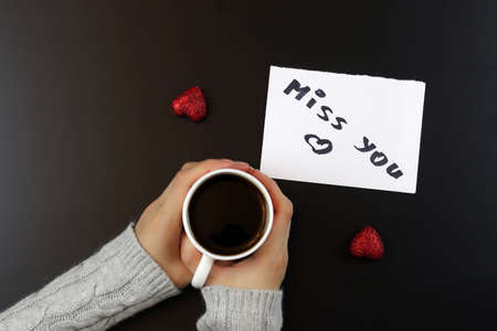 two lovers holding each other's hands and drinking coffee at the tableの写真素材