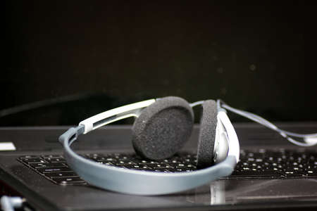 black laptop computer keyboard keys and headphones on itの写真素材