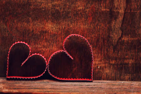 small red paper hearts on a background of brown wood textureの写真素材