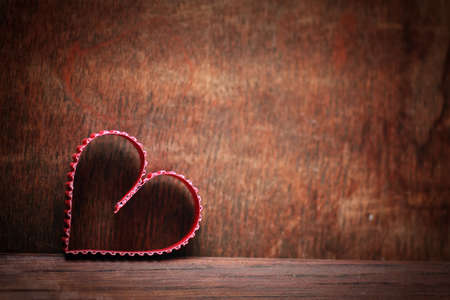 small red paper hearts on a background of brown wood textureの写真素材