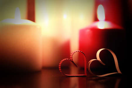 many candles of different sizes and colors on a brown tableの写真素材