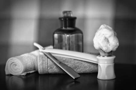 Men's cosmetics shaving brush and straight razor in a wooden basketの写真素材