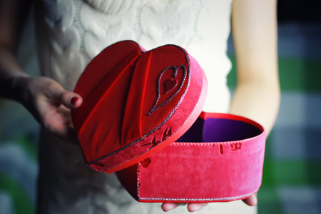 object red heart-shaped hands holding a young person
