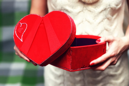 object red heart-shaped hands holding a young person