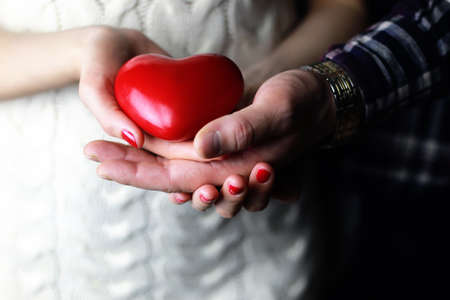 object red heart-shaped hands holding a young personの写真素材