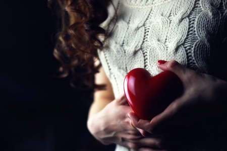 object red heart-shaped hands holding a young personの写真素材