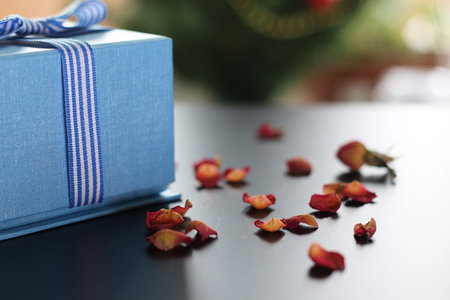 Christmas gift in the blue box with a bow with a bright-colored toysの写真素材