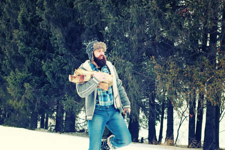bearded handsome man went into the forest with an ax to produce wood for the furnaceの写真素材
