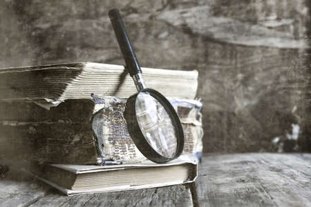old scratched effect on photo magnifying glass and old bookの写真素材