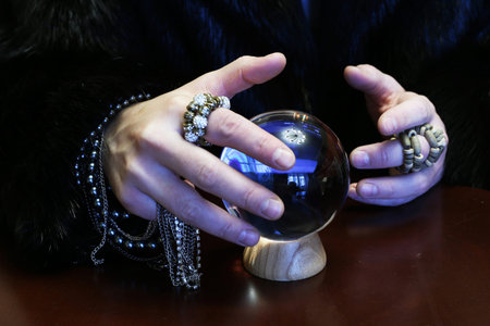 sorcerer hands over a transparent crystal ball fortune-telling for the futureの写真素材