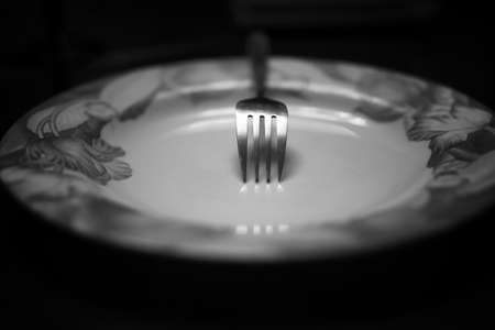 black and white picture fork on an empty plate diningの写真素材