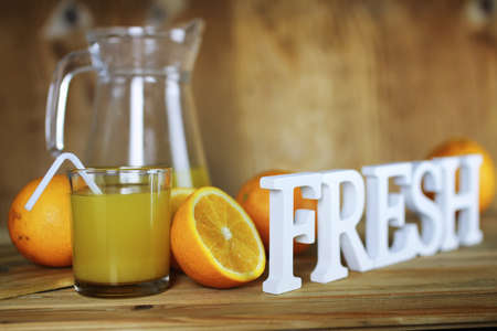 Delicious fresh orange juice on a wooden textural backgroundの写真素材