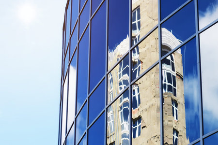 background glass office building windows with reflection of sky in themの写真素材