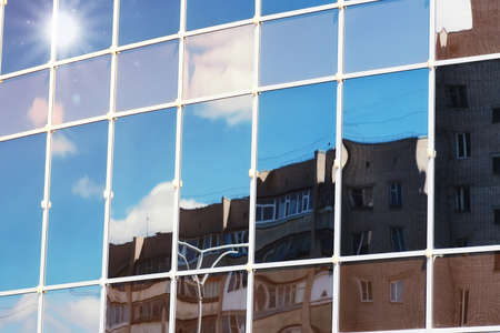 background glass office building windows with reflection of sky in themの写真素材