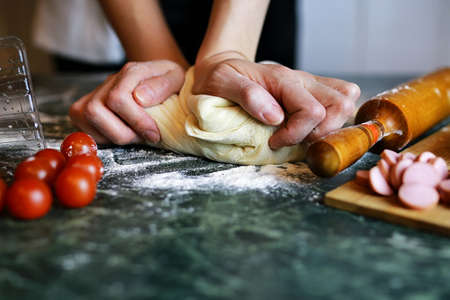 dough for pizza with cherry tomatoes and basil smoked sausageの写真素材
