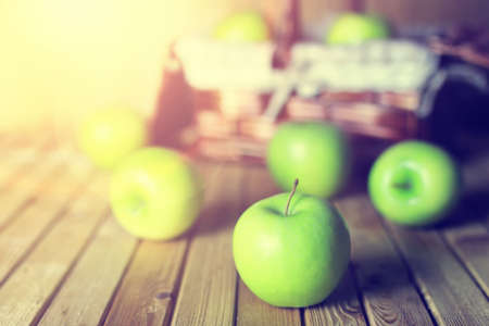 fresh green juicy apples in a basket on a wooden table rusticの写真素材