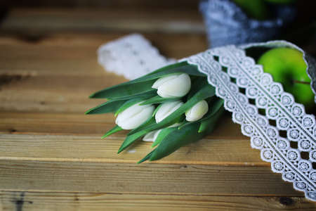 beautiful still life of delicate bouquets of tulips and green applesの写真素材