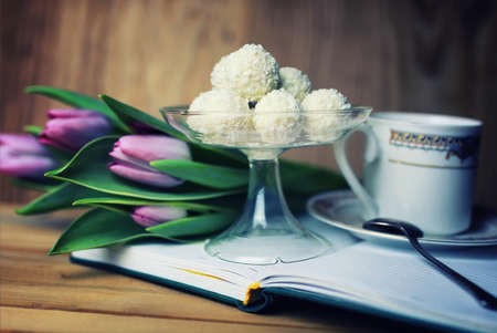 still life on the texture old wooden table bouquet of beautiful tulips an open bookの写真素材