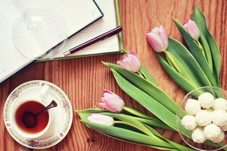 still life on the texture old wooden table bouquet of beautiful tulips an open book
