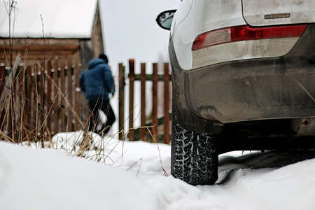 white car standing on the snow-covered countryside, winter roadの写真素材