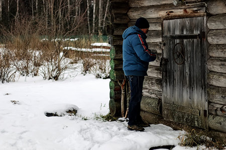 man's hands closed old rusty padlock on an old wooden door of the houseの写真素材