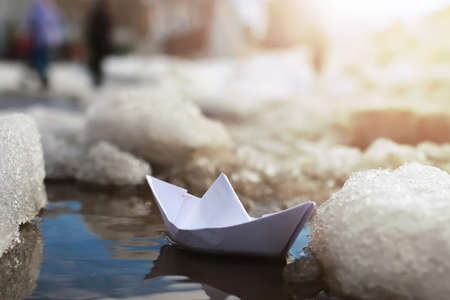small paper folded boat origami method in a spring brook in the parkの写真素材