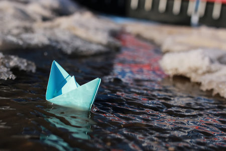 small paper folded boat origami method in a spring brook in the park