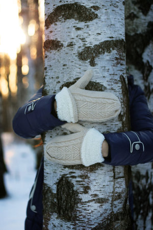 Pretty red-haired girl in the winter forest walks in the snow on a sunny dayの写真素材