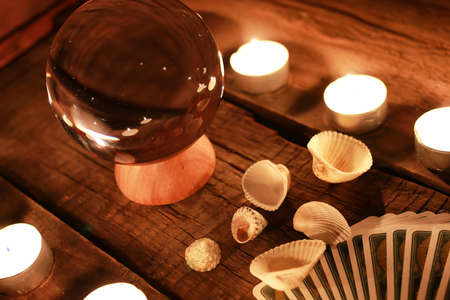 crystal ball for predicting the fate and supernatural action on the table from the old mahogany with candles and cardsの写真素材
