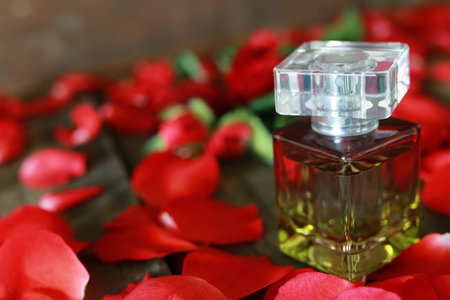 beautiful little bottle with a fragrant perfume on a table with flower petals