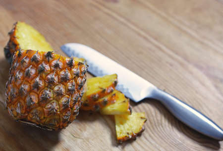 Fresh juicy pineapple on a background of Indian natural texture of wood sheetの写真素材