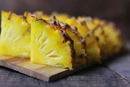 Fresh juicy pineapple on a background of Indian natural texture of wood sheetの写真素材