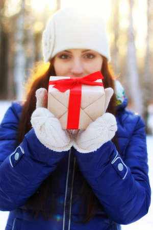 Pretty red-haired girl in the winter forest walks in the snow on a sunny dayの写真素材