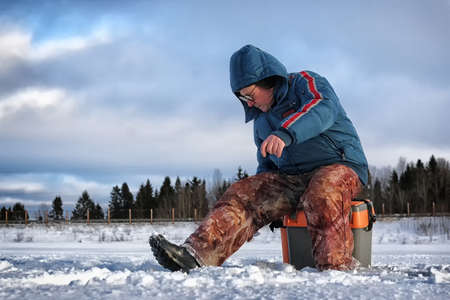 Men's winter fun hike to the pond on the ice-fishingの写真素材