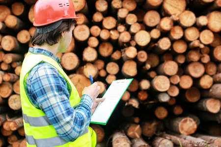 White worker in protective clothing and an orange helmet on workplaceの写真素材