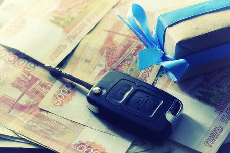 Black keychain car key on a matt black background and moneyの写真素材