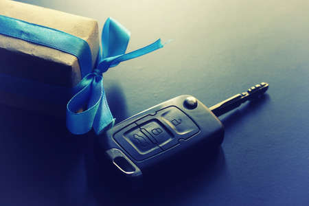 Black keychain car key on a matt black background and moneyの写真素材