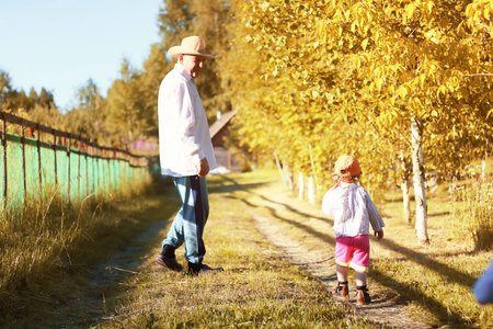 young grandfather bringing up grandchildren on his country area on a summer eveningの写真素材