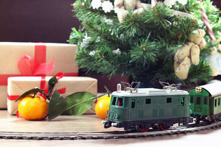 little old toy train on the track and with a motor under the Christmas tree decoratedの写真素材