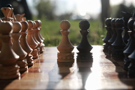 sun glare on the figures in the figures chess board in the park spring eveningの写真素材