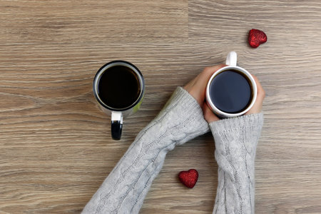 two lovers holding each other's hands and drinking coffee at the table