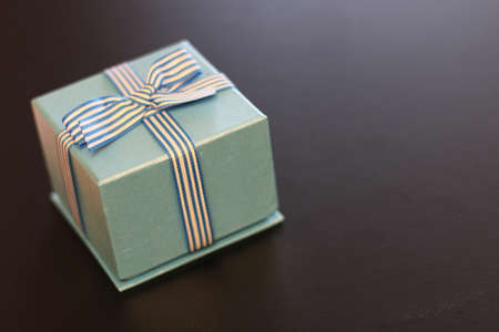 Christmas gift in the blue box with a bow with a bright-colored toysの写真素材