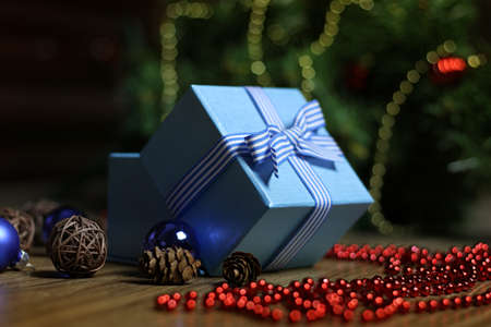 Christmas gift in the blue box with a bow with a bright-colored toysの写真素材
