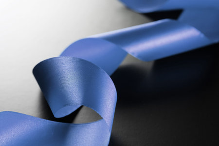 satin ribbon on a black matte background and the shape of the heartの写真素材