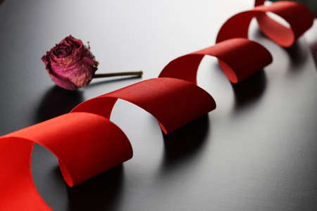 satin ribbon on a black matte background and the shape of the heartの写真素材