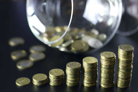 a lot of stacks of coins increasing yellow gradually the concept of progress and growthの写真素材
