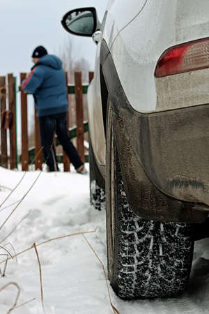 white car standing on the snow-covered countryside, winter roadの写真素材