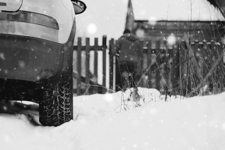 white car standing on the snow-covered countryside, winter road