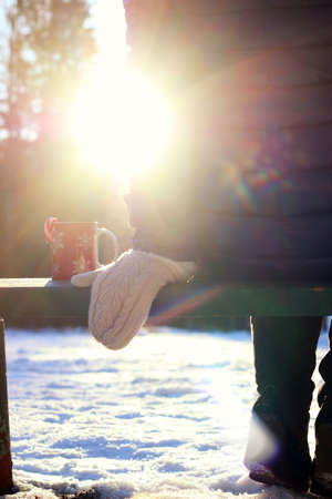 Pretty red-haired girl in the winter forest walks in the snow on a sunny dayの写真素材