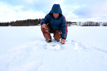 Men's winter fun hike to the pond on the ice-fishingの写真素材
